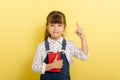 Image of smart little girl child standing isolated over yellow background. Royalty Free Stock Photo