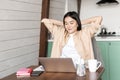 Image of smiling asian girl finish homework or work on laptop, looking pleased at result on computer screen, sitting at