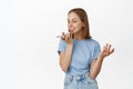 Image of smiling blond girl talking at speakerphone, mobile phone near lips mouth, gesturing while speaking, record Royalty Free Stock Photo