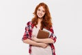 Image of Smiling ginger woman in shirt hugging books