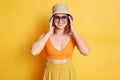 Image of smiling happy positive woman wearing top and panama, posing with raised arms and looking at camera with positive happy