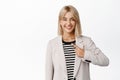 Image of smiling professioal corporate woman, businesswoman pointing finger at herself and looking confident, white