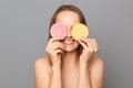 Image of smiling woman covering one eyes with cosmetic sponges, posing isolated on gray background, having fun while doing morning Royalty Free Stock Photo