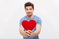 Image of Smiling worried man in t-shirt giving paper heart