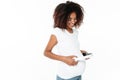 Smiling young pregnant african woman listening music with headphones. Royalty Free Stock Photo