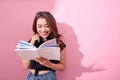 Image of smiling young woman posing isolated over pink background wall holding book reading Royalty Free Stock Photo