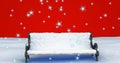 Image of snow falling over snow covered bench on red background Royalty Free Stock Photo