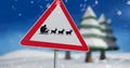 Image of snow falling over road sign with santa claus in sleigh with reindeer in winter scenery Royalty Free Stock Photo