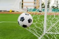 Soccer football in Goal net with green grass field. Royalty Free Stock Photo