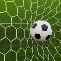 Soccer football in Goal net with green grass field. Royalty Free Stock Photo