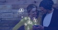 Image of social media icons over caucasian couple using smartphone Royalty Free Stock Photo