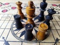 Some chess pieces put on wooden carrom board