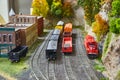 Some miniature toy trains carting goods on train tracks next to old west village