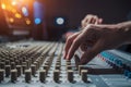 Image Sound engineer adjusting knobs on mixing desk, music production