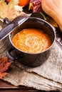 Image of soup puree in saucepan, pumpkin on linen cloth