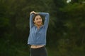 Image of sporty asian woman in sportswear stretching her arms, warming up his body before running in the green park Royalty Free Stock Photo