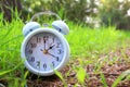 Image of spring Time Change. Summer back concept. Vintage alarm Clock outdoors.