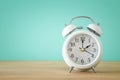 Image of spring Time Change. Summer back concept. Vintage alarm Clock over wooden table.