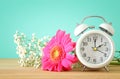 Image of spring Time Change. Summer back concept. Vintage alarm Clock over wooden table. Royalty Free Stock Photo