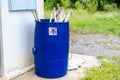 Image of a stack of disused and discarded neon lamp tubes waiting for recycling in the trash with skull mark in blue bin.