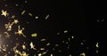 Image of stars floating over confetti on black background Royalty Free Stock Photo