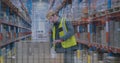 Image of statistical data processing over caucasian male worker working at warehouse Royalty Free Stock Photo