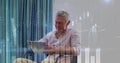 Image of statistical data processing over caucasian man using tablet sitting on chair at home Royalty Free Stock Photo