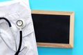 Image of stethoscope and doctor coat over blue background desk. Medical concept Royalty Free Stock Photo