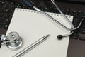 Image of a stethoscope, laptop, pen and notebook with a blank white screen, in the workplace. Space for text Royalty Free Stock Photo