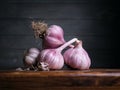 Image of Still Life with stack of Garlic. Dark wood background, antique wooden table