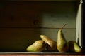 Image of Still Life with a stack of green Pears. Rustic wood background, antique wooden table