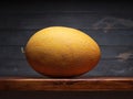 Image of Still Life with yellow Melone. Dark wood background, antique wooden table