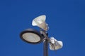 Image of a street lamp post that supports a pair of speakers to inform the population Royalty Free Stock Photo