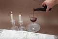 Image subject of Sabbath, a day sacred to the Jewish people. Hand pouring wine cup of sanctification, and Shabbat candles are Royalty Free Stock Photo
