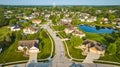 Suburban neighborhood with water tower in distance and pond rich homes aerial Royalty Free Stock Photo