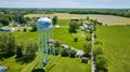 Summer green aerial Pierceton Indiana water tower rural houses, farms, farmland, fields, plowed