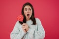 Image of surprised brunette girl posing with lollipop Royalty Free Stock Photo