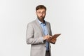 Image of surprised businessman with beard, wearing grey suit and glasses, saying wow and looking impressed after reading Royalty Free Stock Photo