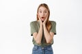 Image of surprised girl in awe, drop jaw and gasping amazed, hear awesome exciting news, holding hands on face, stare at Royalty Free Stock Photo