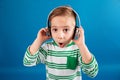 Image of Surprised young boy listening music by headphone Royalty Free Stock Photo