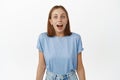 Image of surprised young woman, student drop jaw, gasping and looking in awe at camera, checking out special sale promo Royalty Free Stock Photo