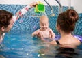 Swimming classes for little ones, infant with mother in swimming pool during training Royalty Free Stock Photo