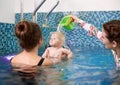 Swimming classes for little ones, infant with mother in swimming pool during training Royalty Free Stock Photo