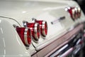 Image of Taillight of an old classic American car, three red round back lights on a white car Royalty Free Stock Photo