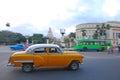 Classic yellow vintage Cuban car fast speeding with blurred background of yank tank tanks, bus & Capitol National at Havana, Cuba Royalty Free Stock Photo