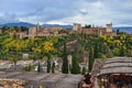 Image taken from the Saint Nicholas viewpoint of the Alhambra landscape on a cloudy autumn day, the forest with green and yellow