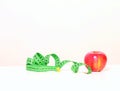 Tasty red apple and tape measure representing slimming and weight loss Royalty Free Stock Photo