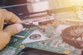 Image technician repairing inside of Notebook by pliers Integrated Circuit