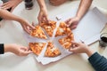 Image of teenage friends hands taking slices of pizza Royalty Free Stock Photo