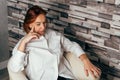 Image of thinking young lady. Sad woman sitting on sofa at home Royalty Free Stock Photo